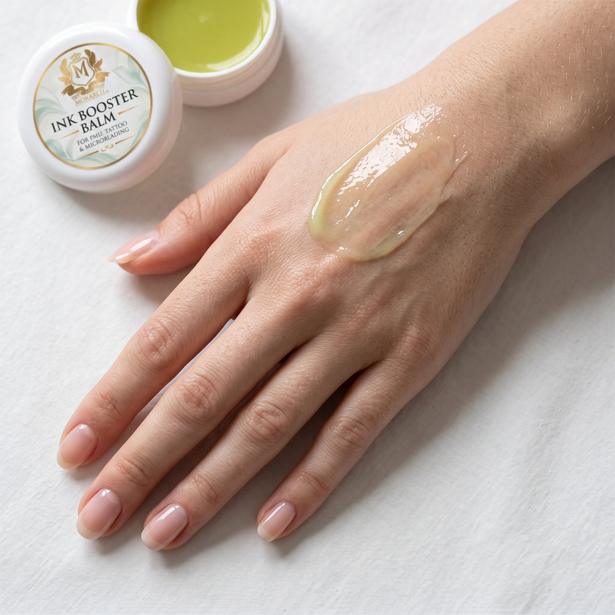 Skin Monarch Ink Booster Balm 30ml, baume brillant étalé sur le dos d'une main