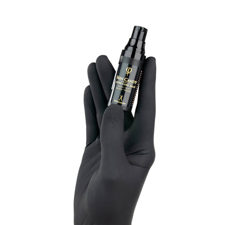 PhiAcademy Skin Candy After Care Balm — aftercare balm bottle held in a gloved hand